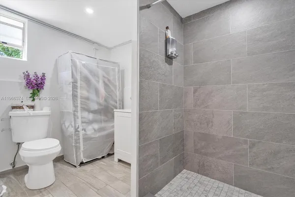 a bathroom with a toilet and a shower