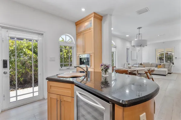 a kitchen with sink and view of living room