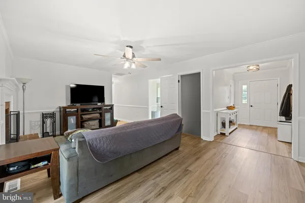 a view of a dining room and livingroom with furniture wooden floor a chandelier