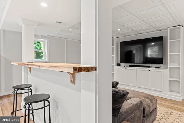 a living room with a bed furniture and a flat screen tv