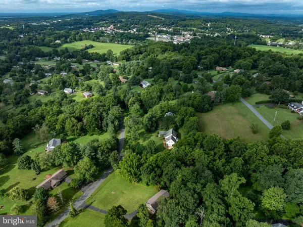 an aerial view of residential houses with outdoor space and trees