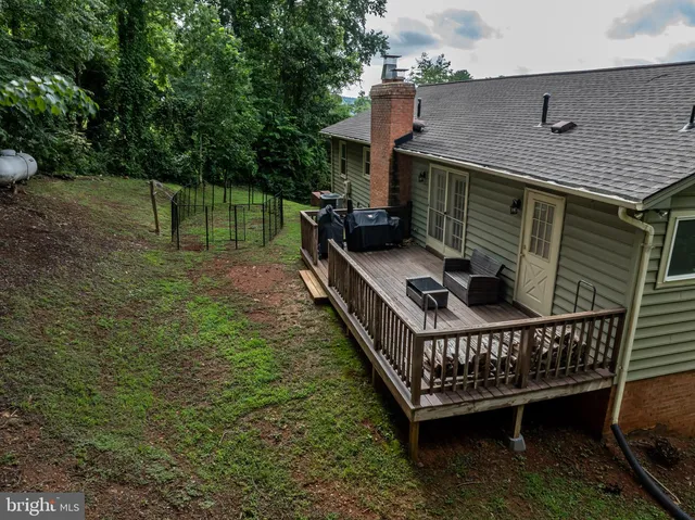 a view of a roof deck with barbeque grill and floor