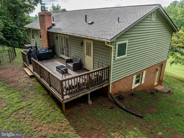 a view of a house with a wooden deck and a yard