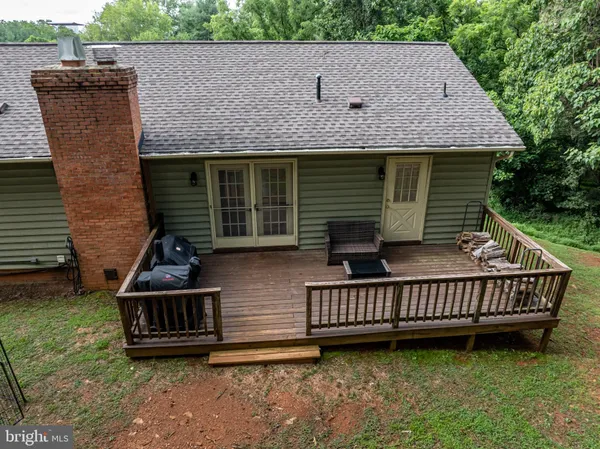 a view of a house with wooden deck and a yard