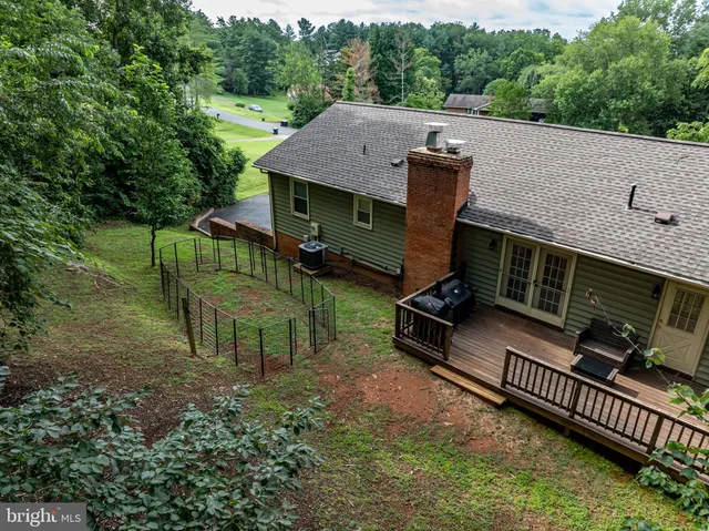 an aerial view of a house with backyard and deck