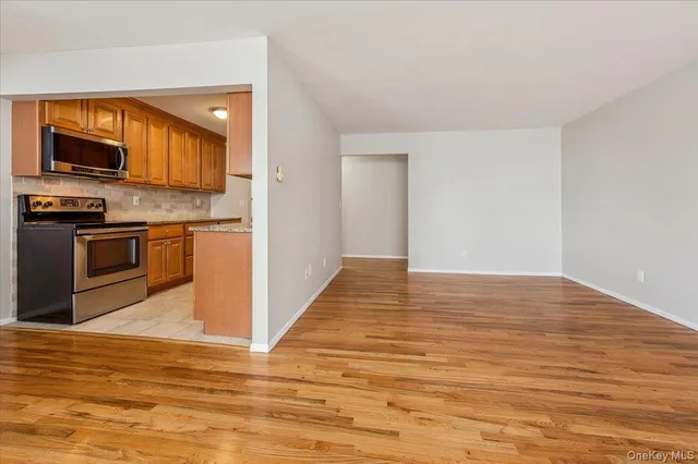 a view of a kitchen with wooden floor a sink and a refrigerator