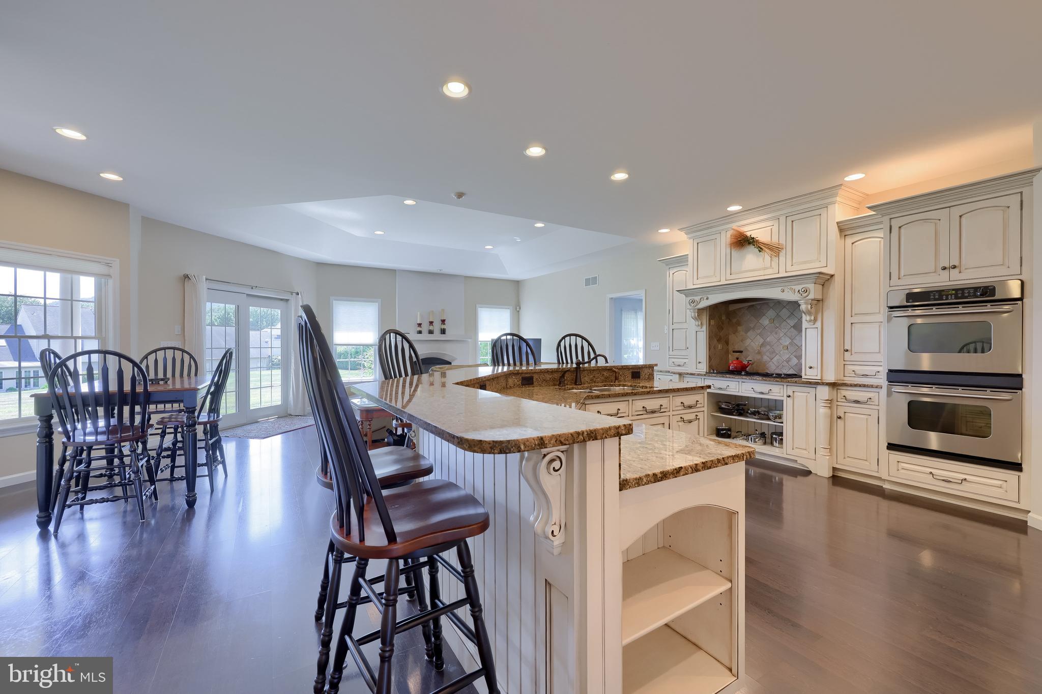 890 Fishburn Road Hershey, PA 17033 - Photo 11 of 103 a kitchen with stainless steel appliances granite countertop a stove top oven a sink a dining table and chairs with wooden floor