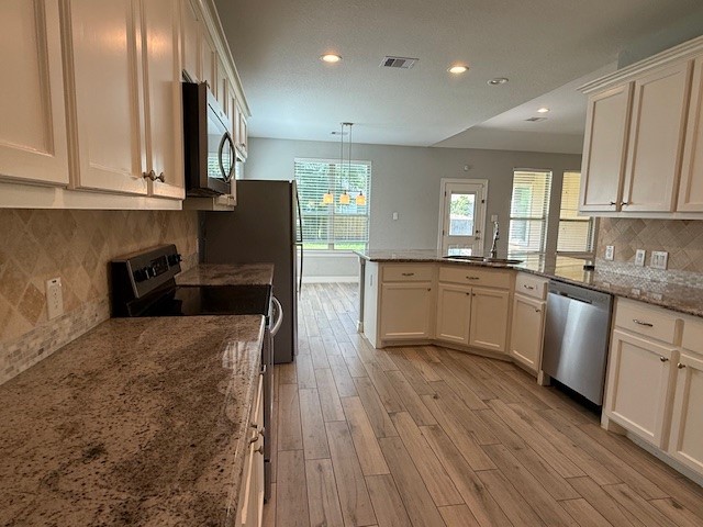 1541 Primrose Street Conroe, TX 77385 - Photo 6 of 25 a kitchen with granite countertop a sink a counter space appliances and cabinets