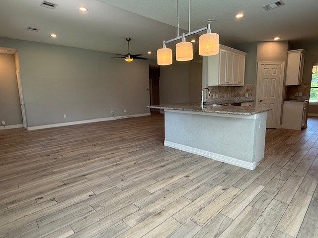 1541 Primrose Street Conroe, TX 77385 - Photo 9 of 25 a large kitchen with stainless steel appliances a large counter top a stove and a wooden floors