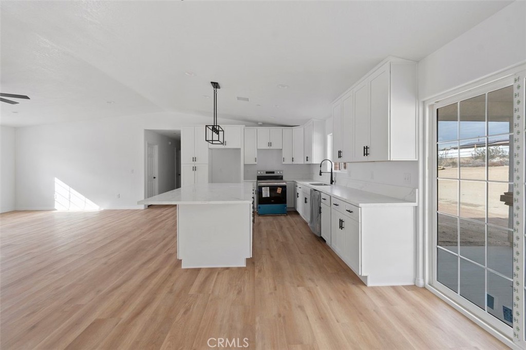 14685 Apple Valley Road Apple Valley, CA 92307 - Photo 16 of 29 a large kitchen with a wooden floor and windows