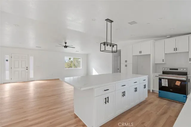 a kitchen with stainless steel appliances granite countertop a sink stove and wooden floor