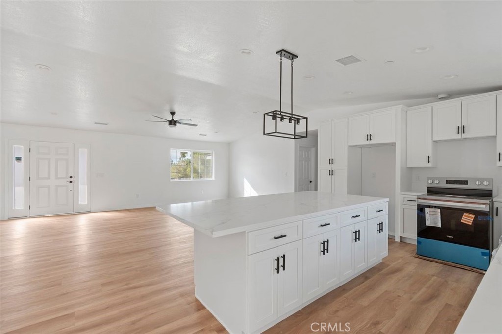 14685 Apple Valley Road Apple Valley, CA 92307 - Photo 22 of 29 a kitchen with stainless steel appliances granite countertop a sink stove and wooden floor