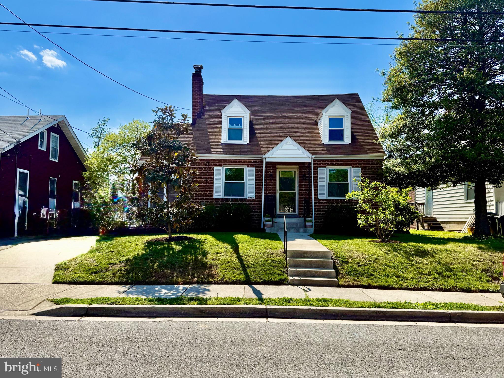 Charming brick home with lush greenery.
