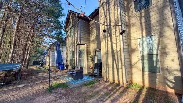 a view of a brick house with many windows next to a road