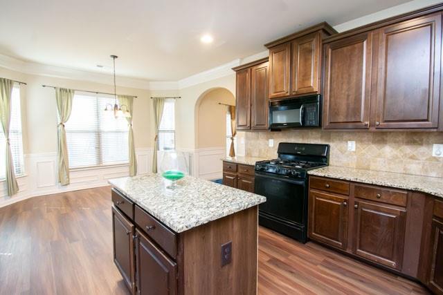 250 Sylvan Loop Fayetteville, GA 30214 - Photo 3 of 18 a kitchen with granite countertop wooden cabinets and black stainless steel appliances