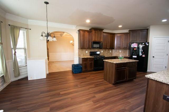 250 Sylvan Loop Fayetteville, GA 30214 - Photo 5 of 18 a kitchen with kitchen island granite countertop wooden floors stainless steel appliances a sink and a window