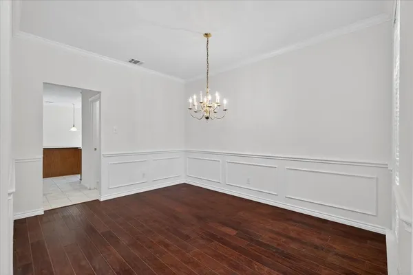 a view of a room with wooden floor and white walls