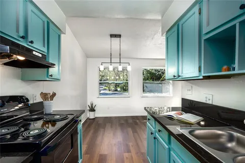 a kitchen with a stove and a wooden floor