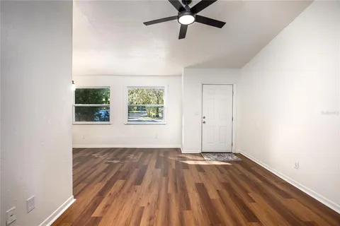 a view of a livingroom with wooden floor and window