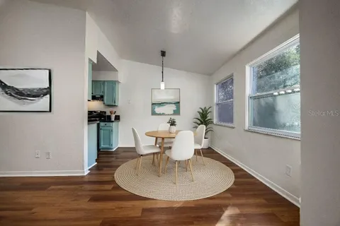 a dining room with furniture a window and wooden floor
