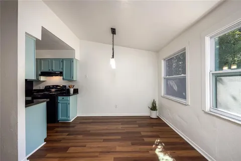 a kitchen with a stove and a wooden floor