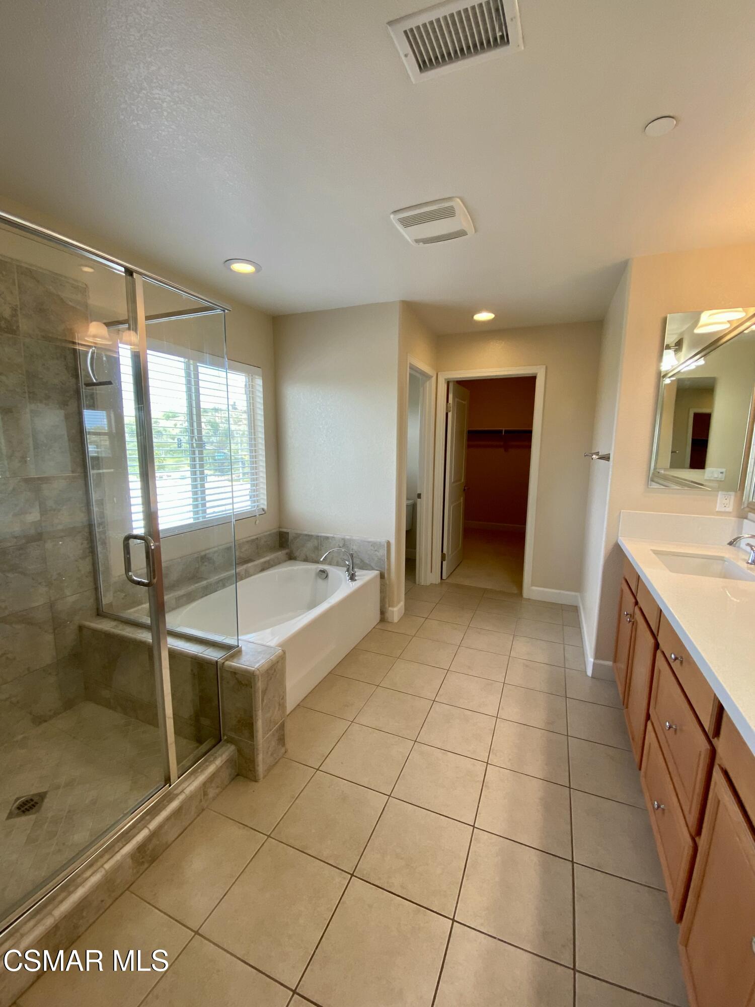 7085 Crozet Avenue Moorpark, CA 93021 - Photo 11 of 22 a spacious bathroom with a granite countertop sink a mirror and a shower