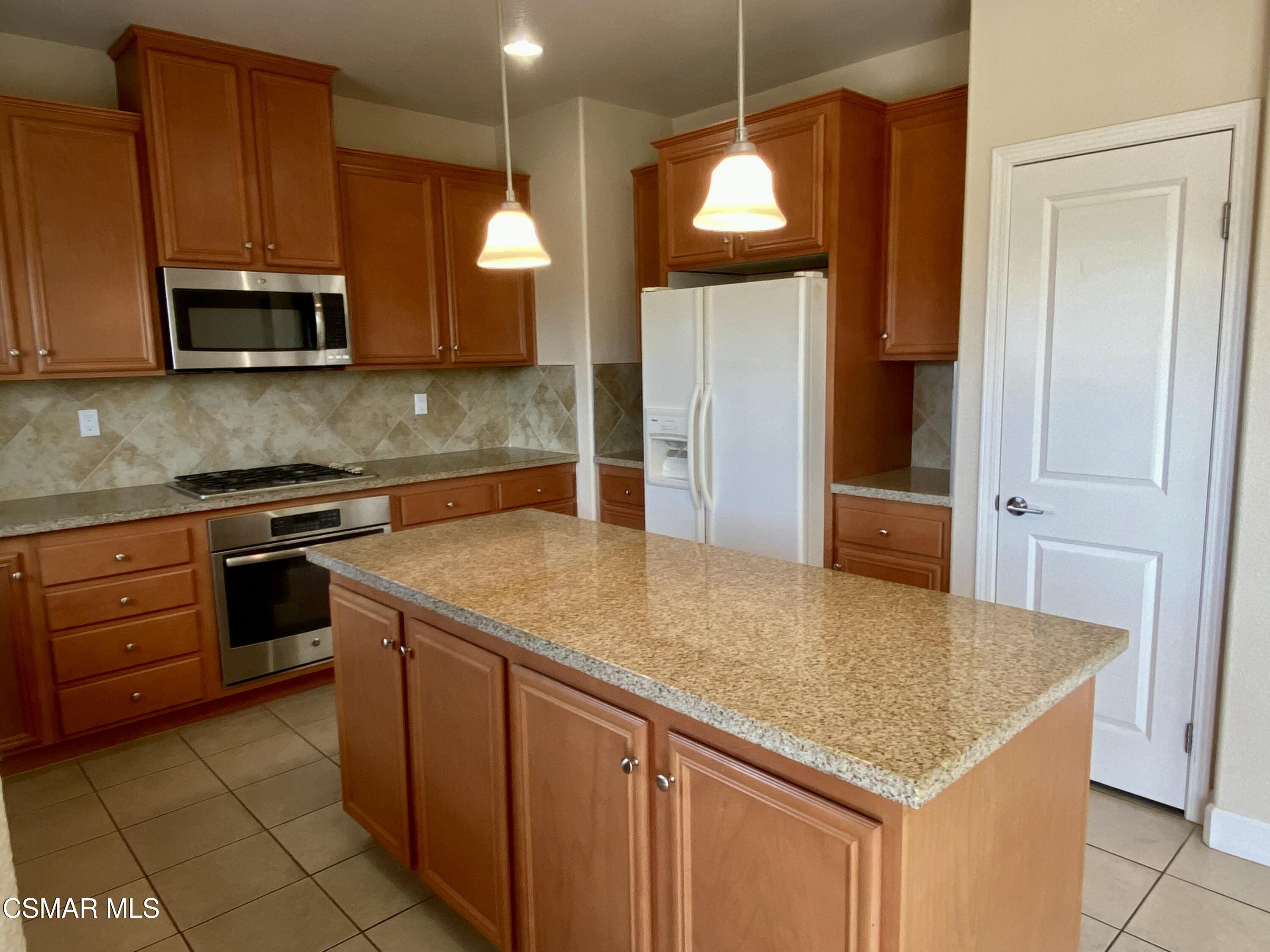 7085 Crozet Avenue Moorpark, CA 93021 - Photo 2 of 22 a kitchen with stainless steel appliances granite countertop a sink a microwave counter space and cabinets