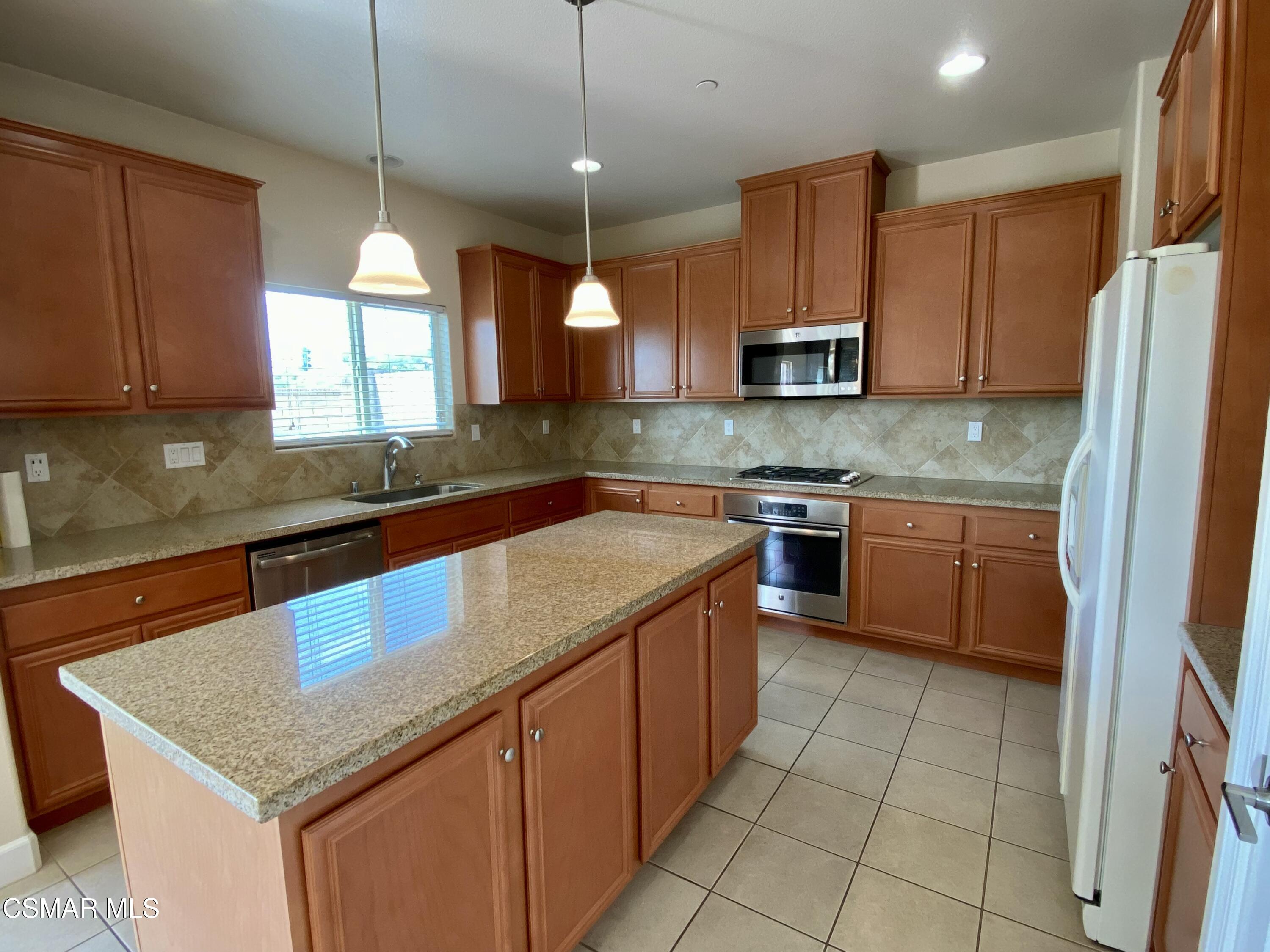 7085 Crozet Avenue Moorpark, CA 93021 - Photo 4 of 22 a kitchen with stainless steel appliances granite countertop a sink counter space cabinets and a large window