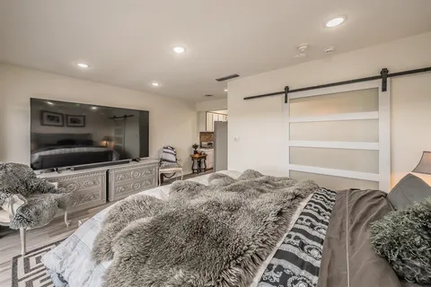 a bedroom with bed and a flat screen tv
