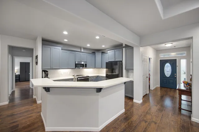 a kitchen with stainless steel appliances granite countertop a sink stove and refrigerator