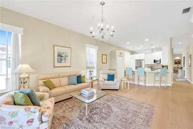 a kitchen with stainless steel appliances granite countertop a stove a refrigerator a microwave a dining table and chairs with wooden floor