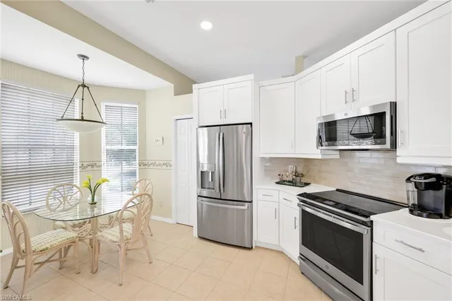 a kitchen with stainless steel appliances granite countertop a stove and white cabinets