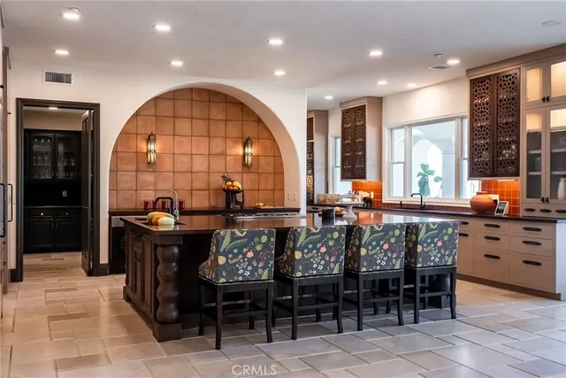 a dining room with wooden floor a chandelier a wooden table and chairs