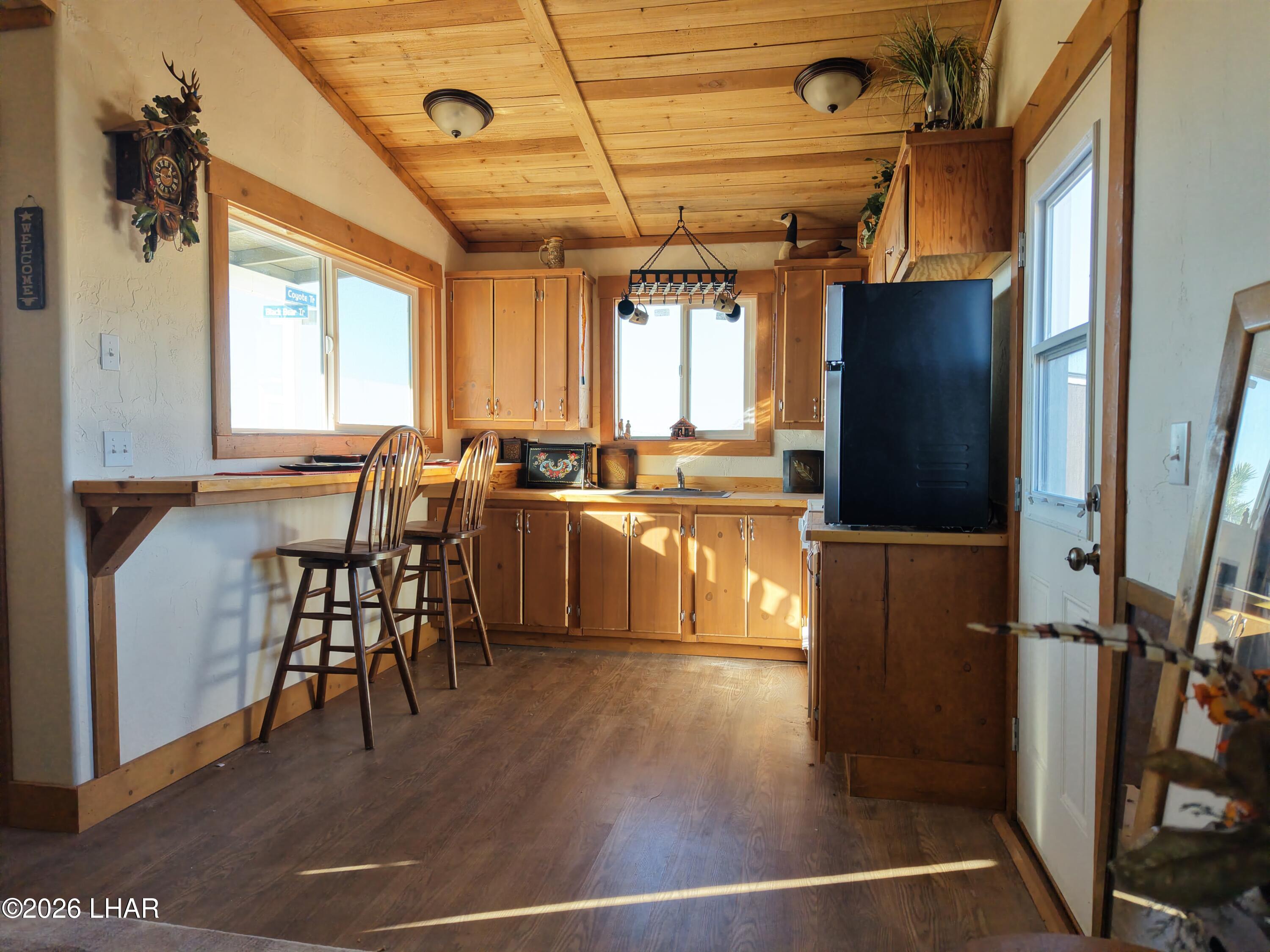 127 South Carrow Road Yucca, AZ 86438 - Photo 20 of 39 a kitchen with stainless steel appliances granite countertop a refrigerator a stove and a dining table with wooden floors