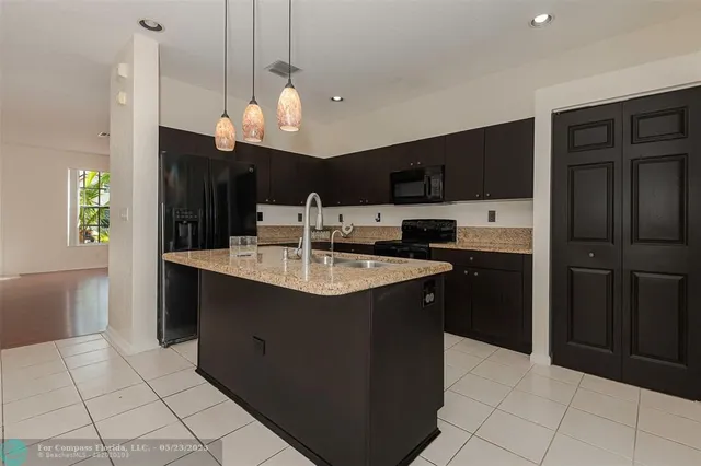 a kitchen with stainless steel appliances granite countertop a refrigerator a sink and a oven