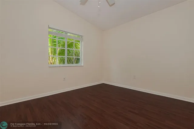 an empty room with wooden floor and a window