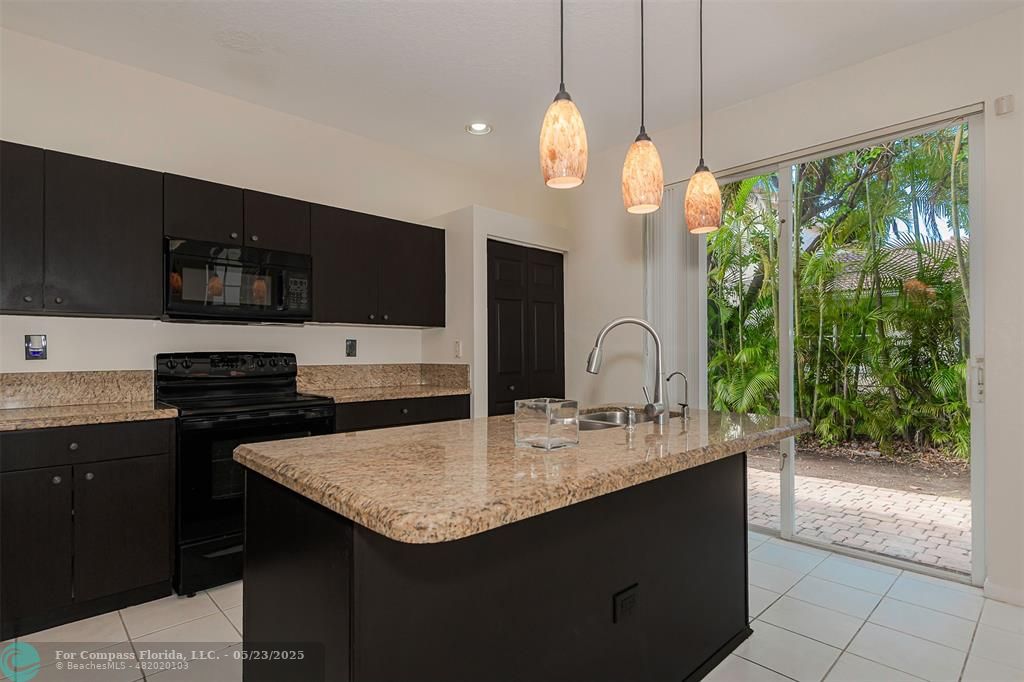 18798 Southwest 28th Street, Unit 18798 Miramar, FL 33029 - Photo 8 of 28 a kitchen with kitchen island granite countertop a sink and a stove