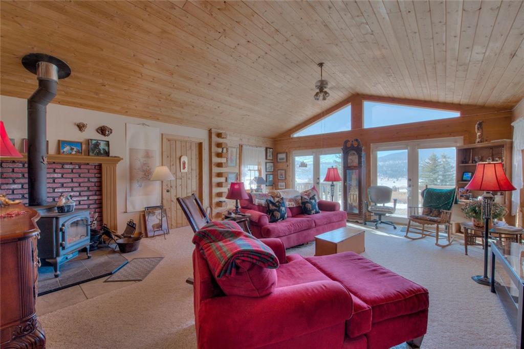 468 Wagon Wheel Road Hartsel, CO 80449 - Photo 11 of 30 a living room with furniture a flat screen tv and a floor to ceiling window