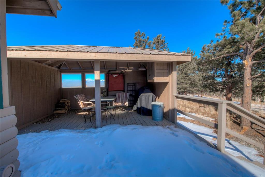 468 Wagon Wheel Road Hartsel, CO 80449 - Photo 28 of 30 a view of a patio with table and chairs with wooden floor and fence