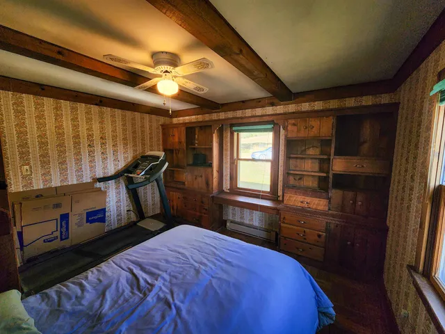 a bed room with a bed dresser and a window