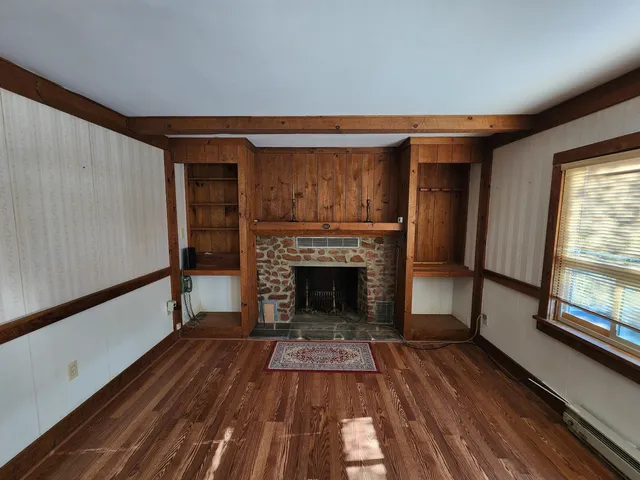 a living room with a fireplace and wooden floor