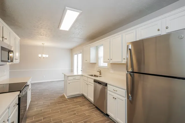 a kitchen with white cabinets and white appliances