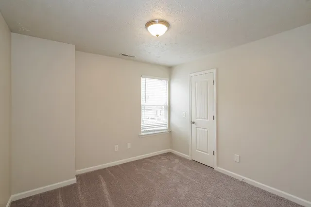 an empty room with windows and closet in a room