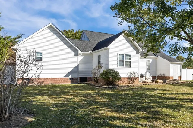 a view of a house with backyard and trees