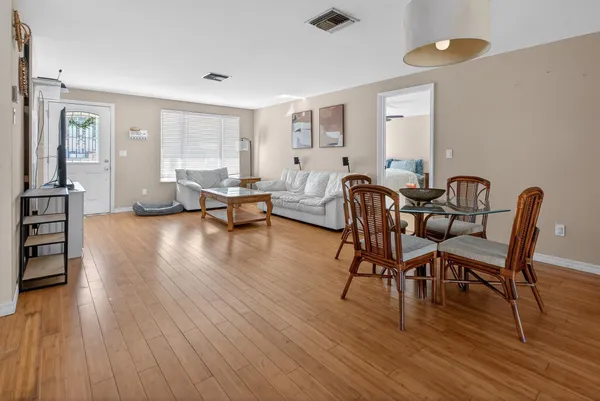 a spacious bedroom with a bed and a flat tv screen on dresser