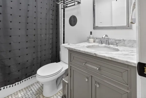 a bathroom with a granite countertop toilet sink and mirror