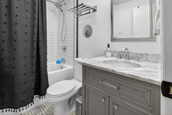 a bathroom with a granite countertop toilet sink and mirror