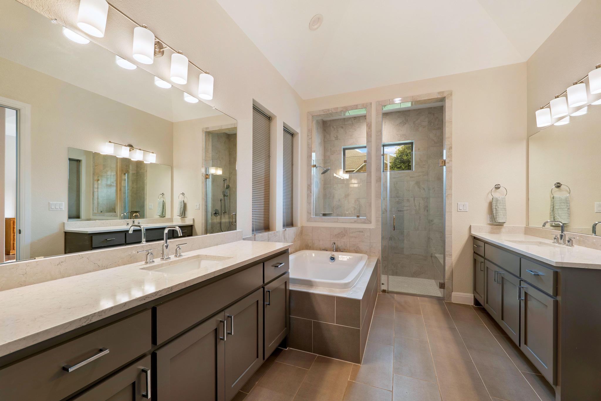 1009 Legacy Crossing Georgetown, TX 78628 - Photo 25 of 40 A well-appointed primary bath features dual vanities, a luxurious soaking tub, and a spacious walk-in shower.