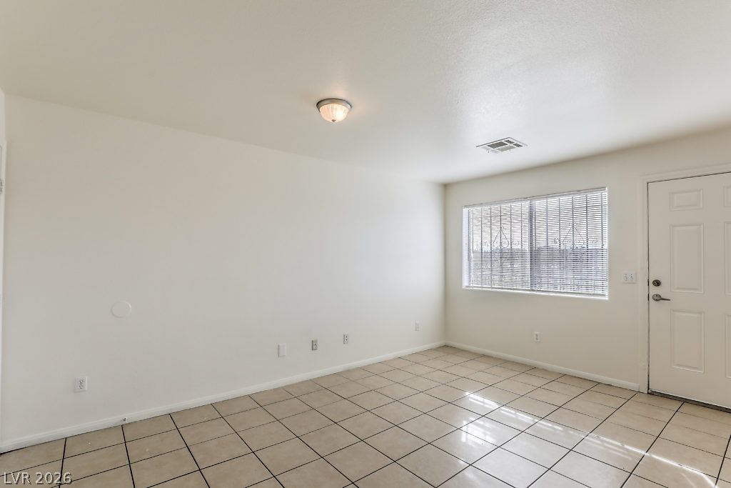 3127 North Walnut Road, Unit A Las Vegas, NV 89115 - Photo 5 of 12 A well-lit, neutral-toned living space offers durable tile flooring and a bright window.