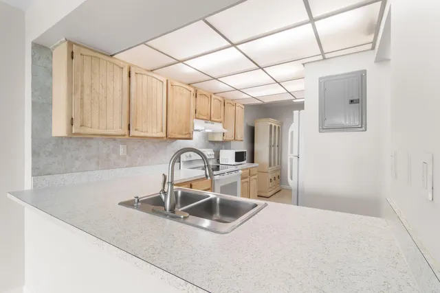 a kitchen with white cabinets and white appliances